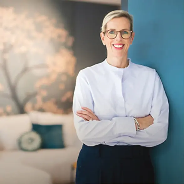 Drei Personen sitzen am Tisch und betrachten Stoffmuster, Beraterin in der Mitte, zwei Kunden gegenüber